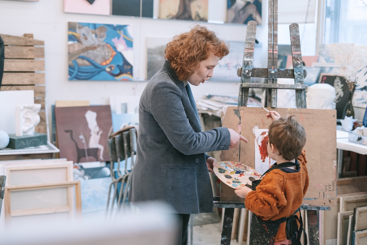 Teaching and student in front of a small canvas