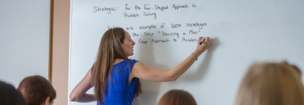 Faculty member writing on white board